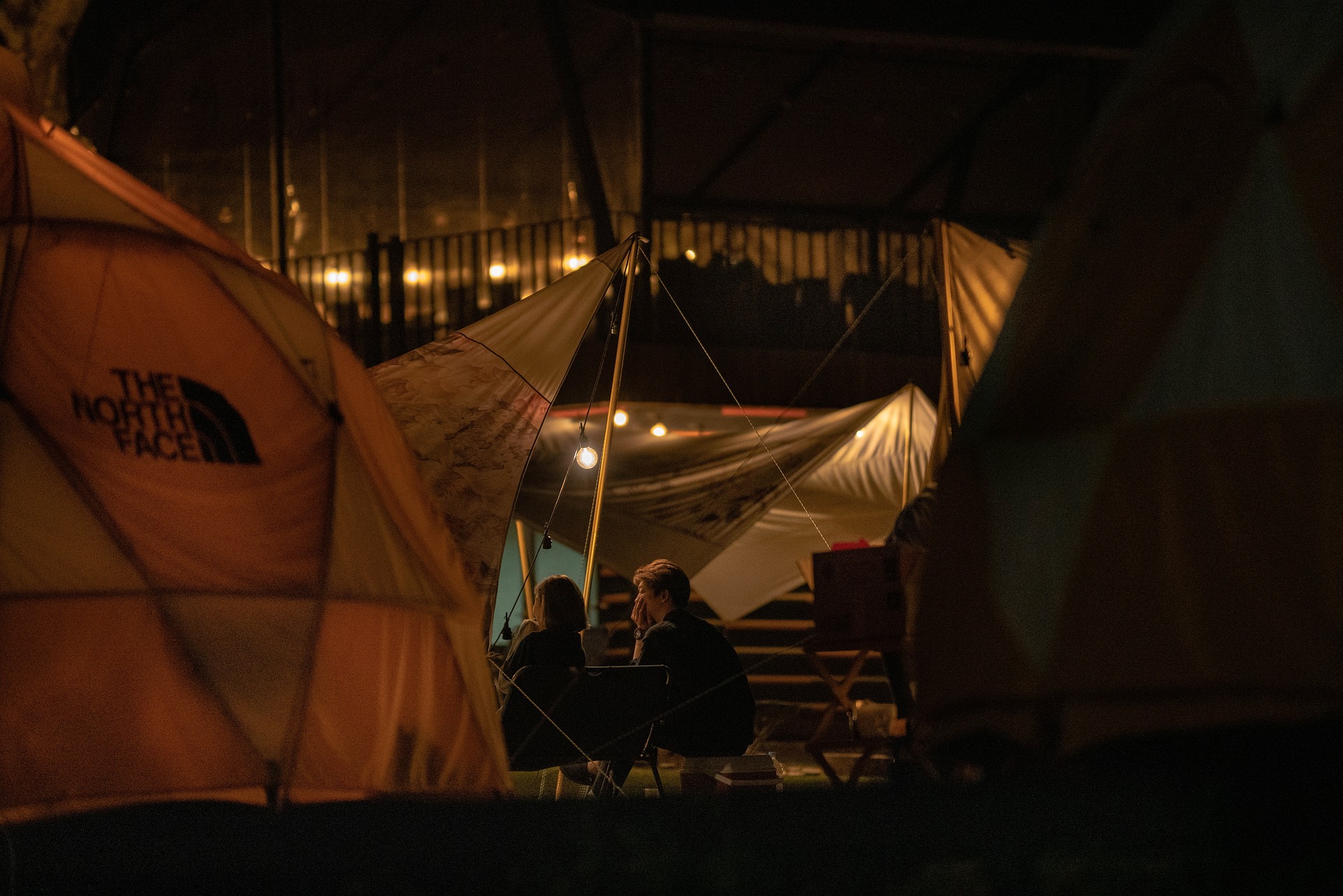 Tents lit up at a campsite at night