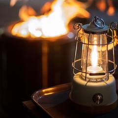 Camp lantern glowing beside a fire