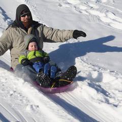 Man wearing a neck gaiter while sledding