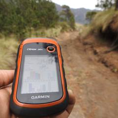 Handheld Garmin GPS unit on a trail